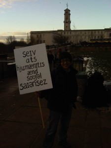 Me, at dawn, holding a placard reading "Save Arts, Humanities and Social Sciences" in International Phonetic Alphabet